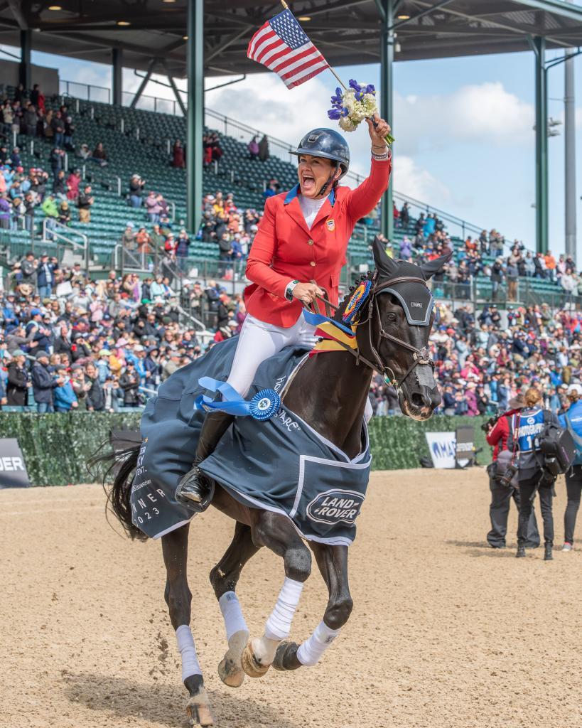 Rider Tamie Smith riding her horse at the track, waving a flag with a bouquet in hand. Used by MagnaWavePEMF
